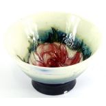 A Moorcroft pottery flared bowl, decorated centrally with an anemone on a cream and navy blue