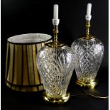 A pair of Waterford crystal baluster shaped lamp bases, each with gilt brass mounts and with cream