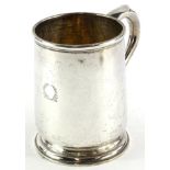 A George V silver plain mug, engraved with a wreath, with a shaped handle and domed foot,