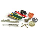A collection of militaria, to include a plated Bosun's whistle, various medal ribbons, a cap badge