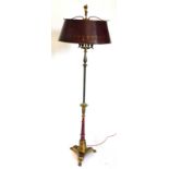 A continental gilt brass and red coloured standard lamp, the concave platform base with paw feet,