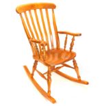 An ash and elm slatback Windsor rocking chair, with shaped arms, solid seat on turned tapering