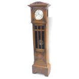 An early 20thC oak cased longcase clock, the silvered dial with Arabic numerals and brass bezel,