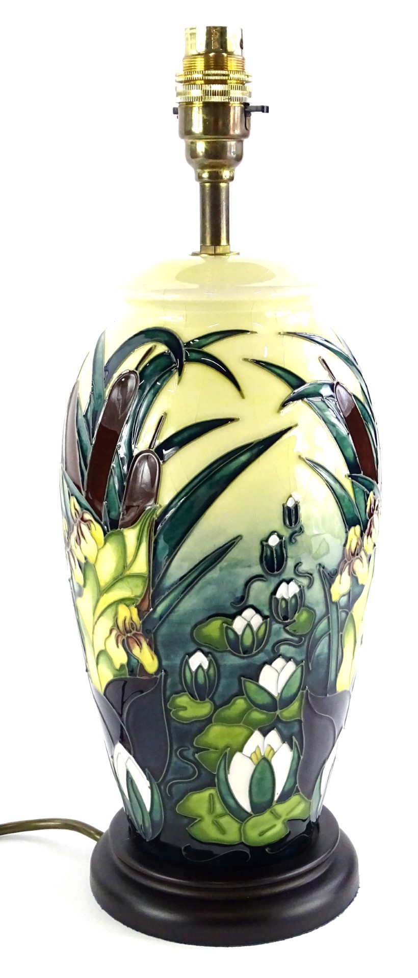 A Moorcroft pottery lamp base, decorated with rushes and lilies, on a cream ground with brass