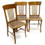 A set of three beech and elm early 20thC dining chairs, each with a shaped back, upright rails and a