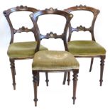 A set of three Victorian walnut dining chairs, each with a cartouche shaped back, a padded seat,