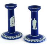 A pair of dark blue Wedgwood Jasperware candlesticks, each decorated with neo-classical figures