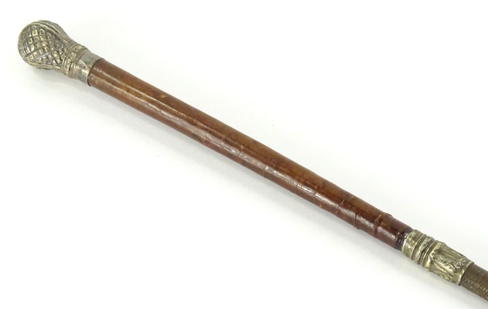 A brown leather riding crop, with gilt white metal mounts cast and embossed with flowers, etc.,