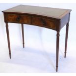 A mahogany writing table, the top with a green leather inset and a concave front, above two frieze