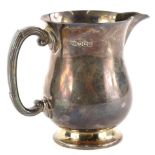 A George VI silver jug, of baluster form with reeded handle and tapering foot, engraved D.G.C. 1956,