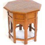 An Indian brass and hardwood octagonal folding table, decorated overall with leaves, geometric