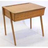 A mid to late 20thC child's desk, with a hinged lid enclosing a vacant interior, on shaped legs,