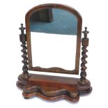 A Victorian mahogany dressing table mirror, the rectangular plate with an arched top on spirally