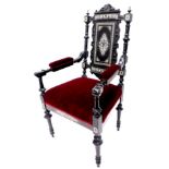 A late Victorian ebonised and ivory inlaid open armchair, the panelled back decorated with