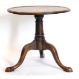 A mahogany low table, the circular dished top on a turned column and tripod base, formerly part of a