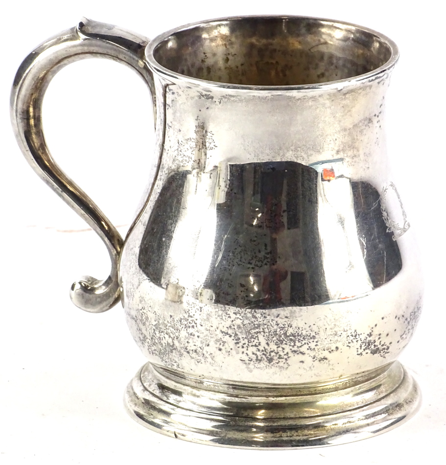 A George V baluster shaped mug, engraved with a laurel wreath and with shaped handle, inscribed to