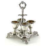 A William IV silver egg cup stand, of quatrefoil shape with recesses for spoons, scroll handle and