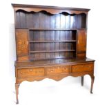 An early 19thC oak and mahogany crossbanded dresser, the raised back with a moulded cornice, above a
