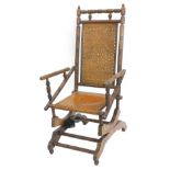An American turned walnut rocking chair, with a pierced ply back and seat, on turned supports.