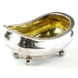 A George III silver boat shaped salt, with a gadrooned edge, gilt interior on bun feet, engraved