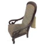 A Victorian mahogany show frame armchair, with a padded back and seat on scroll carved legs.