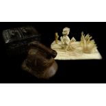 A late 19thC carved ivory figure group of a young boy, a dog and a swan, on a rectangular base,