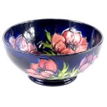 A Moorcroft pottery bowl, decorated with poppies, on a navy blue ground, impressed mark to