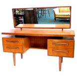 A G-Plan 1970's/80's teak dressing table, with a rectangular mirror, the top with a moulded edge, on