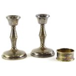 A pair of Elizabeth II silver candlesticks, each with a waisted column and a domed foot, loaded,