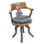 A Victorian walnut office chair, with a shaped back and pierced splat and a circular leather