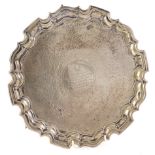 A George V silver salver, with a shaped border and hammered decoration overall, engraved centrally