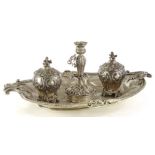 A Victorian silver inkstand, of oval form, with a shaped edge, engraved with a crest and with leaf