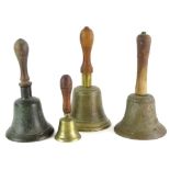 Four brass bells, each with a turned wood handle, the largest 27.5cm high.