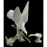 Three Lladro birds, to include a dove, seated on a branch of blossom, a wren and a goose.
