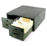 A large quantity of loose stamps, contained in a green metal index drawer cabinet.