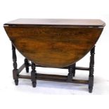 An oak oval drop leaf table, the top with a moulded edge on turn supports, 103cm wide.