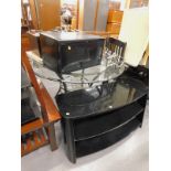 A glass three tier TV stand, a glass topped table with metal base, a Kenwood 900w microwave, metal