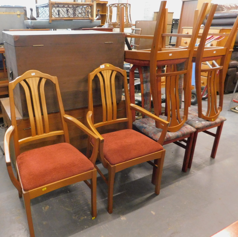 A set of four teak Nathan dining chairs, and two associated armchairs (6). The upholstery in this