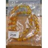 A modern imitation amber beaded necklace, with clear yellow beads of graduating size.