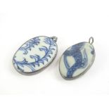 Two delft set and silver framed pendants, the first with white porcelain and blue fernspray design