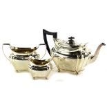 An Edwardian silver three piece tea set, the teapot with an ebonised knop and handle, of melon
