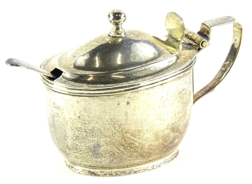 A George V silver oval mustard pot, with blue glass liner, angular handle, London 1921, an