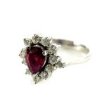An 18ct white gold floral cluster ring, set with tier drop design, central ruby, surrounded by round