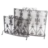 Two similar wrought iron spark guards, 74cm and 61cm wide.