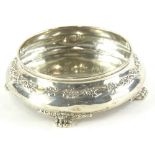 An American Tiffany silver shallow bowl, decorated with flowers and scrolls, with paw feet,