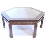 An oriental hardwood octagonal coffee table, with a glass insert, carved frieze on shaped legs, 94cm