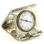 A George V silver cased travelling clock, the dial with Arabic numerals, stamped eight days, the