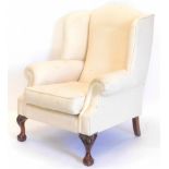 A wingback armchair in mid 18thC style, upholstered in cream tweed type fabric, on cabriole legs