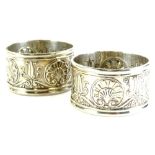 A pair of Victorian silver napkin rings, cast with shells, scrolls, etc., in neo classical design,