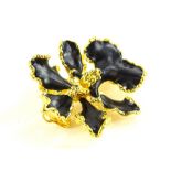 A modern costume jewellery brooch in the design of a flower, with black enamel type design,